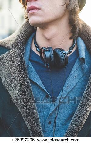 Stock Photograph - Man with headphones hung around neck. Fotosearch