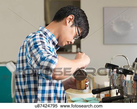 Stock Photography - Man working behind coffee bar. Fotosearch