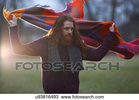 Man wrapping blanket around himself in countryside View Large Photo Image Stock Image - Man wrapping blanket around himself in countryside. Fotosearch