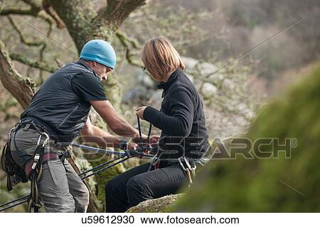 Mature man and mid adult woman putting on climbing ropes View Large Photo Image Stock Image - Mature man and mid adult woman putting on climbing ropes. Fotosearch