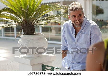 Stock Photo - "Mature man chatting on sidewalk, Copacabana, Rio De Janeiro, Brazil". Fotosearch