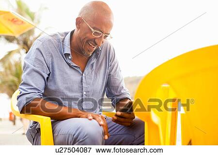 "Mature man reading smartphone texts at bar on Ipanema beach, Rio De Janeiro, Brazil" View Large Photo Image Stock Photo - "Mature man reading smartphone texts at bar on Ipanema beach, Rio De Janeiro, Brazil". Fotosearch