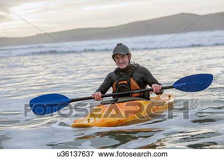 Stock Photo - Mature man sea kayaking. Fotosearch