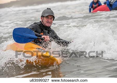 Stock Photo - Mature man sea kayaking. Fotosearch
