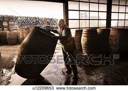 Stock Image - Mature man working in cooperage. Fotosearch