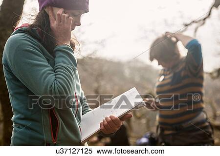 Mature woman using cell phone with notebook View Large Photo Image Stock Photography - Mature woman using cell phone with notebook. Fotosearch