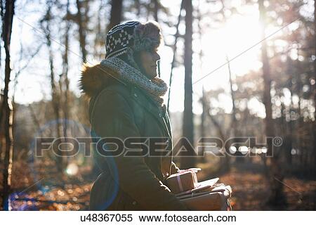 Mature woman walking through sunlit forest carrying gifts View Large Photo Image Stock Photography - Mature woman walking through sunlit forest carrying gifts. Fotosearch