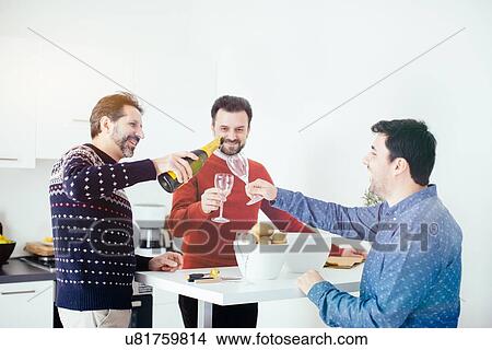 Men enjoying champagne while peeling potatoes in kitchen View Large Photo Image Picture - Men enjoying champagne while peeling potatoes in kitchen. Fotosearch