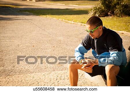 Mid adult man sitting in park View Large Photo Image Stock Photo - Mid adult man sitting in park. Fotosearch