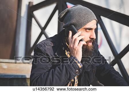 "Mid adult man, sitting outdoors, using mobile phone" View Large Photo Image Stock Image - "Mid adult man, sitting outdoors, using mobile phone". Fotosearch