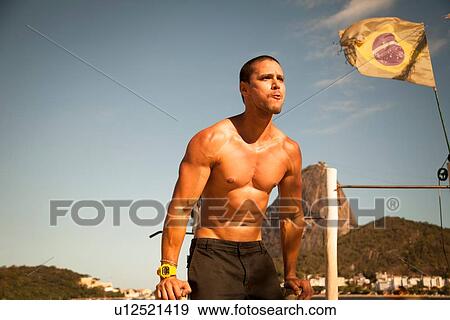 Stock Photo - "Mid adult man training on parallel bars, Rio De Janeiro, Brazil". Fotosearch