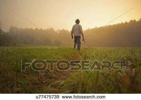 "Mid adult man walking through field with fishing rod, Sarsy village, Sverdlovsk Region, Russia" View Large Photo Image Stock Photo - "Mid adult man walking through field with fishing rod, Sarsy village, Sverdlovsk Region, Russia". Fotosearch