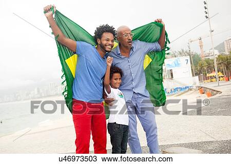 "Mid adult man with father and son holding up Brazilian flag on Ipanema beach, Rio De Janeiro, Brazil" View Large Photo Image Stock Image - "Mid adult man with father and son holding up Brazilian flag on Ipanema beach, Rio De Janeiro, Brazil". Fotosearch