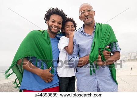 "Mid adult man with father and son wrapped in Brazilian flag on Ipanema beach, Rio De Janeiro, Brazil" View Large Photo Image Stock Photo - "Mid adult man with father and son wrapped in Brazilian flag on Ipanema beach, Rio De Janeiro, Brazil". Fotosearch
