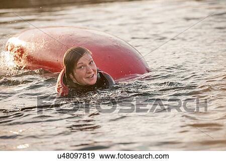 Stock Photo - Mid adult woman falling in water with kayak. Fotosearch