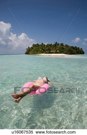 "Mid adult woman floating on rubber ring in Indian Ocean, Maldives" View Large Photo Image Stock Photography - "Mid adult woman floating on rubber ring in Indian Ocean, Maldives". Fotosearch