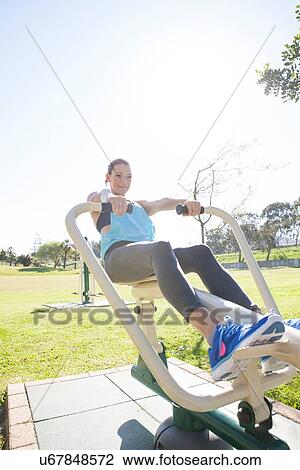 Mid adult woman in park training on rowing machine View Large Photo Image Stock Image - Mid adult woman in park training on rowing machine. Fotosearch