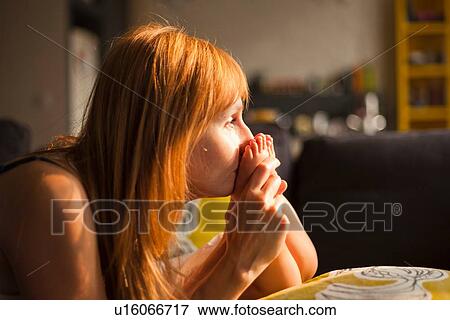 Mid adult woman kissing feet of toddler son in living room View Large Photo Image Stock Photo - Mid adult woman kissing feet of toddler son in living room. Fotosearch