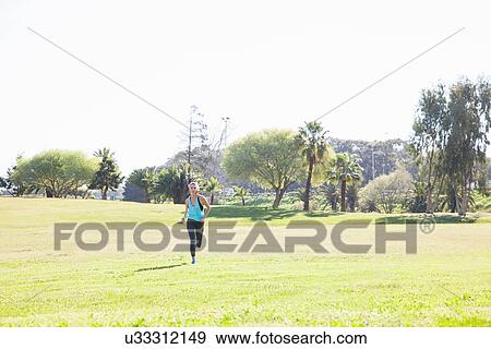 Mid adult woman on training run in park View Large Photo Image Stock Photo - Mid adult woman on training run in park. Fotosearch