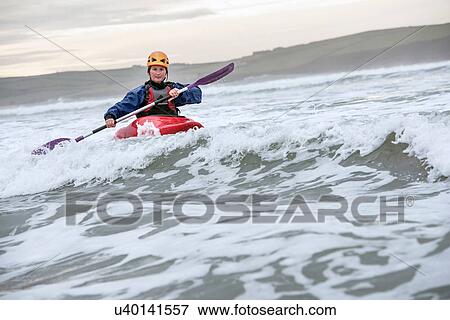Mid adult woman sea kayaking View Large Photo Image Stock Photo - Mid adult woman sea kayaking. Fotosearch