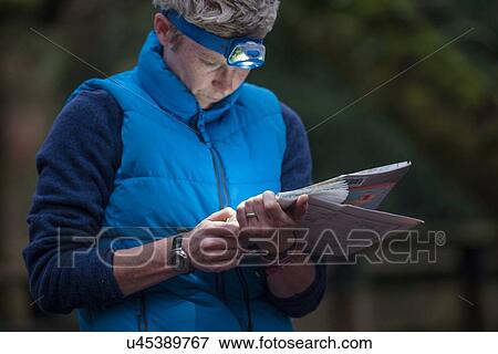 Stock Photo - Mid adult woman studying map. Fotosearch