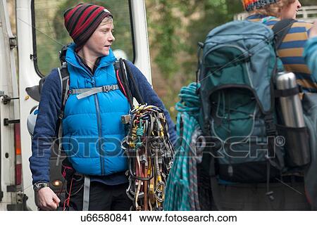 Stock Image - Mid adult woman wearing bodywarmer with climbing ropes. Fotosearch