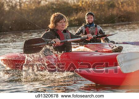 Mid adult women kayaking on lake View Large Photo Image Stock Photo - Mid adult women kayaking on lake. Fotosearch