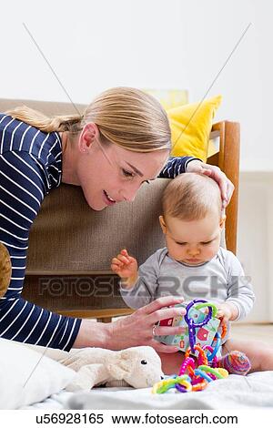 Stock Photography - "Mother and baby girl, at home, playing together". Fotosearch