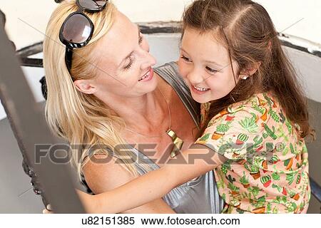 Stock Photography - "Mother and daughter hugging and laughing, elevated view". Fotosearch
