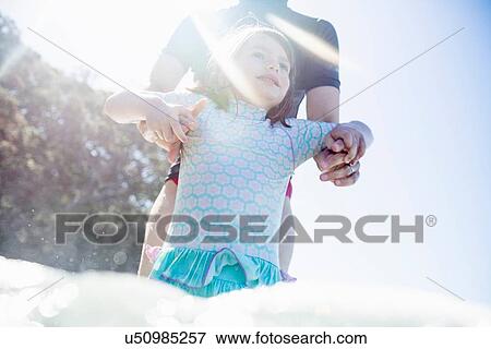 "Mother and daughter jumping waves in sea, Hot Water Beach, Bay of Islands, New Zealand" View Large Photo Image Stock Photo - "Mother and daughter jumping waves in sea, Hot Water Beach, Bay of Islands, New Zealand". Fotosearch