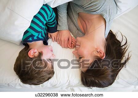 "Mother and son relaxing together in bed, overhead view" View Large Photo Image Stock Photo - "Mother and son relaxing together in bed, overhead view". Fotosearch