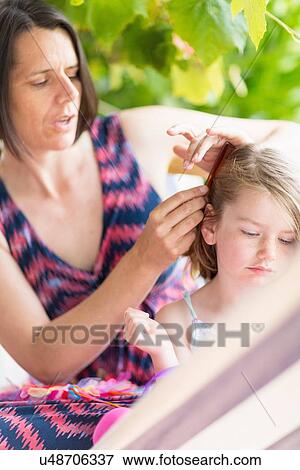 Mother combing daughter's hair View Large Photo Image Stock Photo - Mother combing daughter's hair. Fotosearch