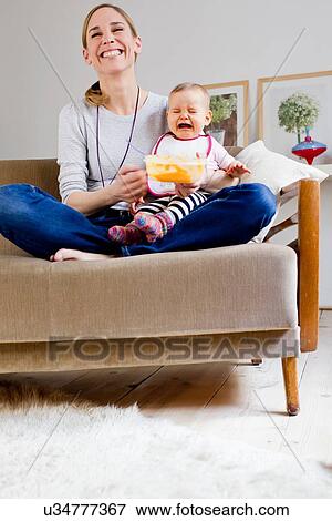 "Mother feeding baby girl, baby crying" View Large Photo Image Stock Photo - "Mother feeding baby girl, baby crying". Fotosearch