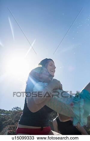 "Mother lifting girl over ocean waves, Hot Water Beach, Bay of Islands, New Zealand" View Large Photo Image Stock Image - "Mother lifting girl over ocean waves, Hot Water Beach, Bay of Islands, New Zealand". Fotosearch