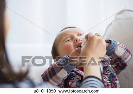 Mother wiping baby boy's face View Large Photo Image Stock Image - Mother wiping baby boy's face. Fotosearch