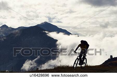 Stock Photograph - "Mountain biker in mountains, Valais, Switzerland". Fotosearch