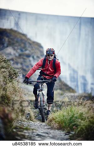 Stock Photography - "Mountain biker on dirt track, Valais, Switzerland". Fotosearch