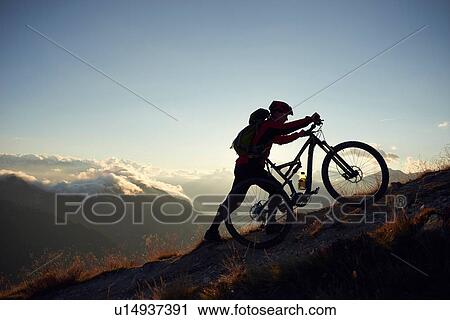 "Mountain biker pushing bike uphill, Valais, Switzerland" View Large Photo Image Stock Image - "Mountain biker pushing bike uphill, Valais, Switzerland". Fotosearch