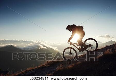 Stock Image - "Mountain biker riding downhill, Valais, Switzerland". Fotosearch