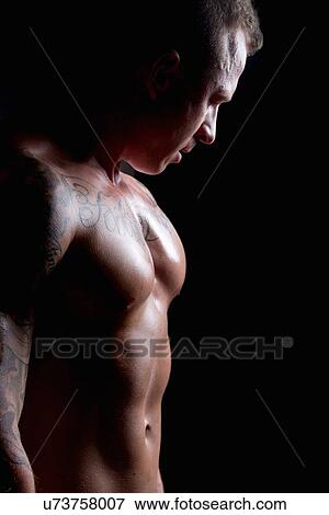 Stock Photo - Muscular young man side lit. Fotosearch