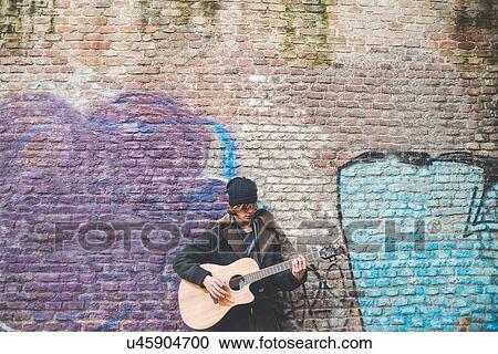 "Musician playing guitar by canal wall, Milan, Italy" View Large Photo Image Stock Image - "Musician playing guitar by canal wall, Milan, Italy". Fotosearch