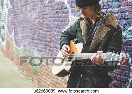 "Musician playing guitar by canal wall, Milan, Italy" View Large Photo Image Stock Photo - "Musician playing guitar by canal wall, Milan, Italy". Fotosearch