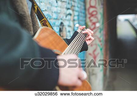 "Musician playing guitar by canal wall, Milan, Italy" View Large Photo Image Stock Photograph - "Musician playing guitar by canal wall, Milan, Italy". Fotosearch