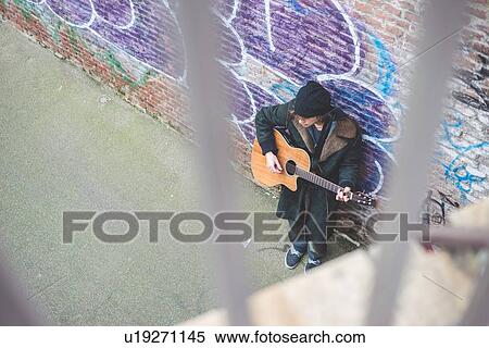 "Musician playing guitar by canal wall, Milan, Italy" View Large Photo Image Stock Photography - "Musician playing guitar by canal wall, Milan, Italy". Fotosearch