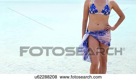 "Neck down view of young woman wearing bikini and sarong on beach, Israel" View Large Photo Image Stock Photo - "Neck down view of young woman wearing bikini and sarong on beach, Israel". Fotosearch