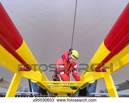 "Offshore windfarm worker climbing turbine, high angle view" View Large Photo Image Stock Image - "Offshore windfarm worker climbing turbine, high angle view". Fotosearch