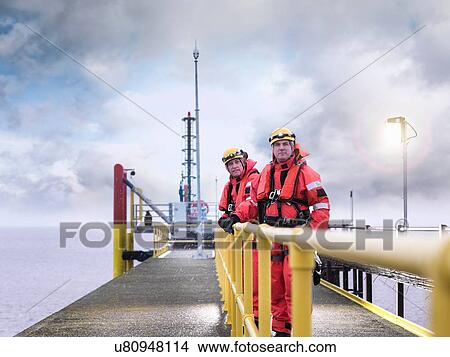 Picture - "Offshore windfarm workers on jetty at sea, portrait". Fotosearch