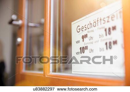 Stock Photo - Opening hours sign on door of cafe. Fotosearch