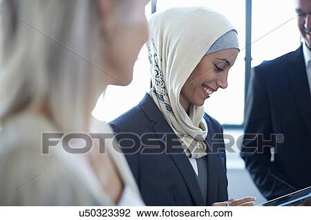 Over shoulder view of businesswomen and man chatting in office View Large Photo Image Stock Image - Over shoulder view of businesswomen and man chatting in office. Fotosearch