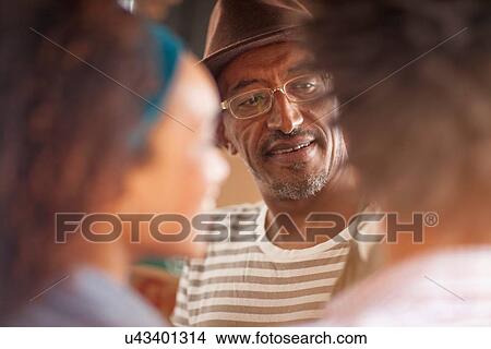 Picture - "Over shoulder view of mature man chatting to couple, Ipanema beach, Rio De Janeiro, Brazil". Fotosearch